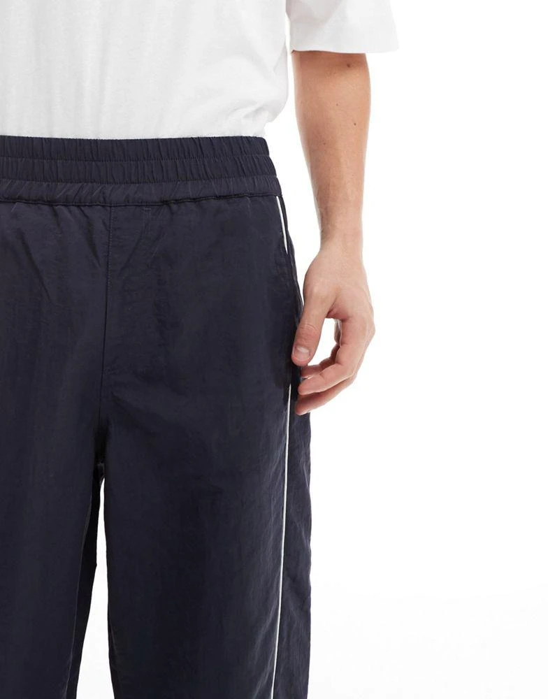 ASOS ASOS DESIGN baggy nylon track pants with white piping in navy 3
