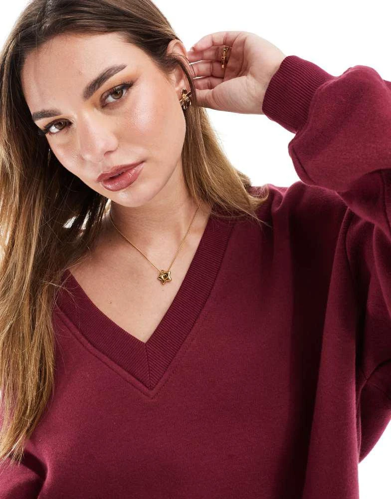 Shop Bershka v-neck sweatshirt in burgundy on Sale at BeyondStyle