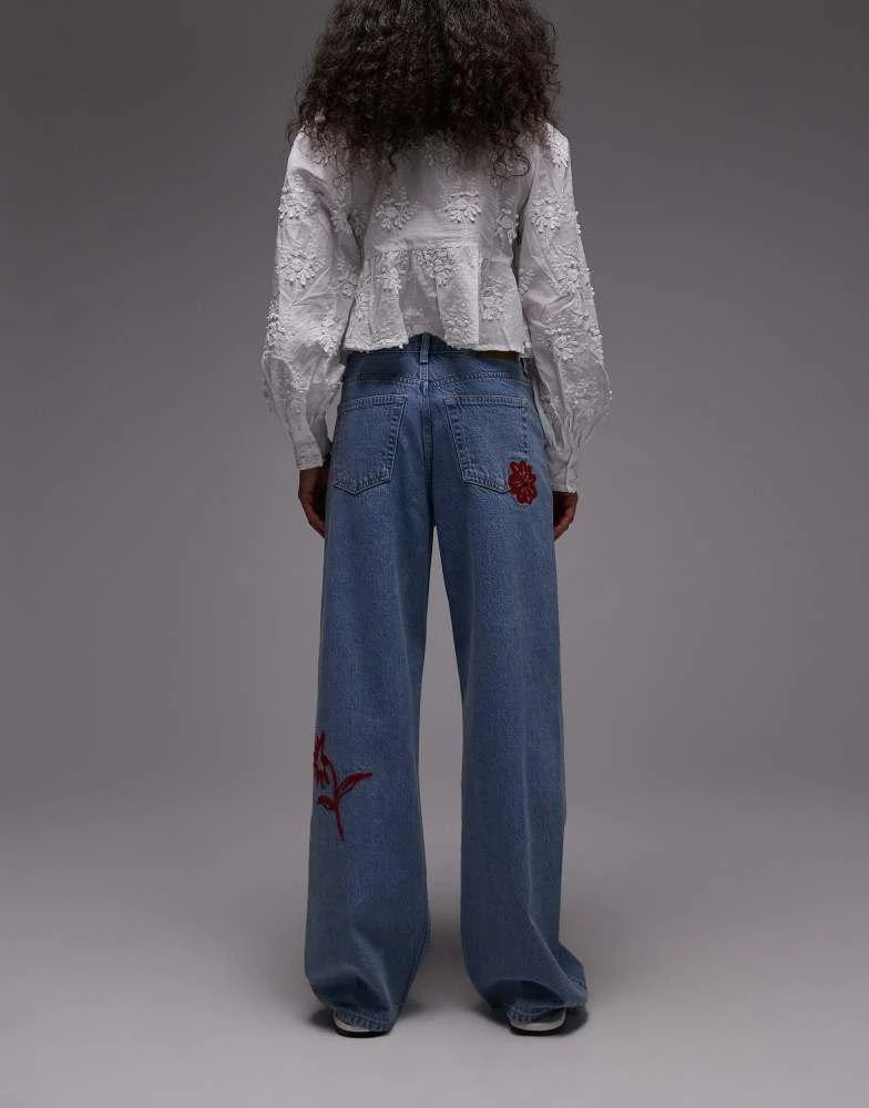 Topshop Topshop mid rise loose fit jean with red floral embroidery in mid blue 2