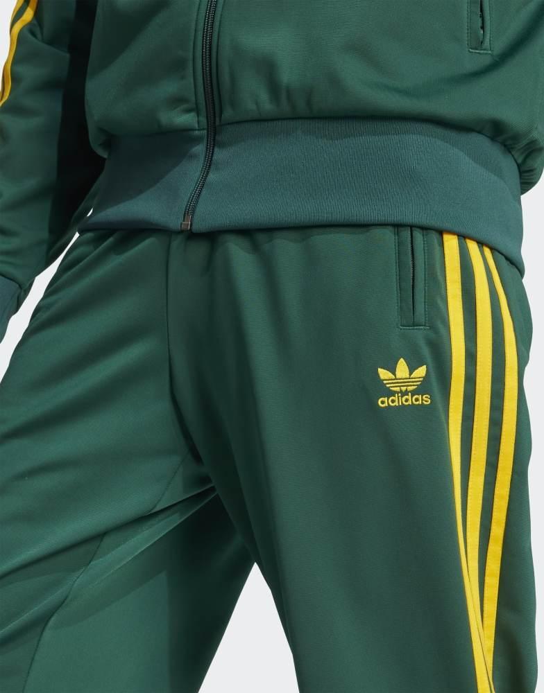 Shop adidas Originals Firebird track pants in green and