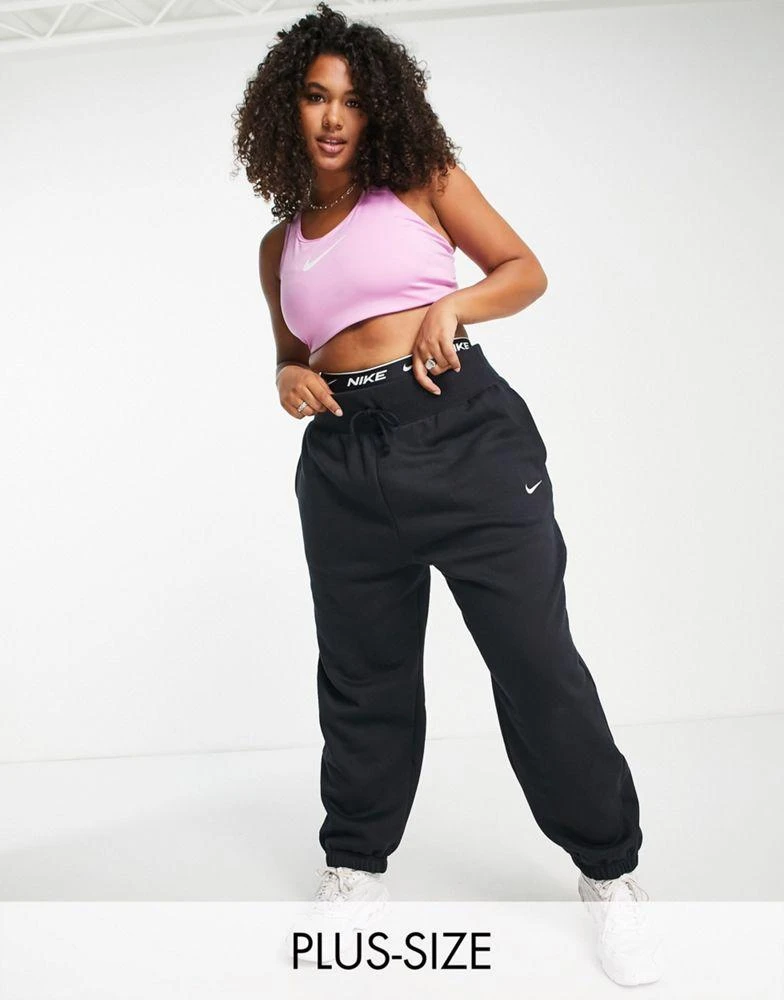 NIKE Nike Plus mini swoosh oversized high rise joggers in black and sail 1