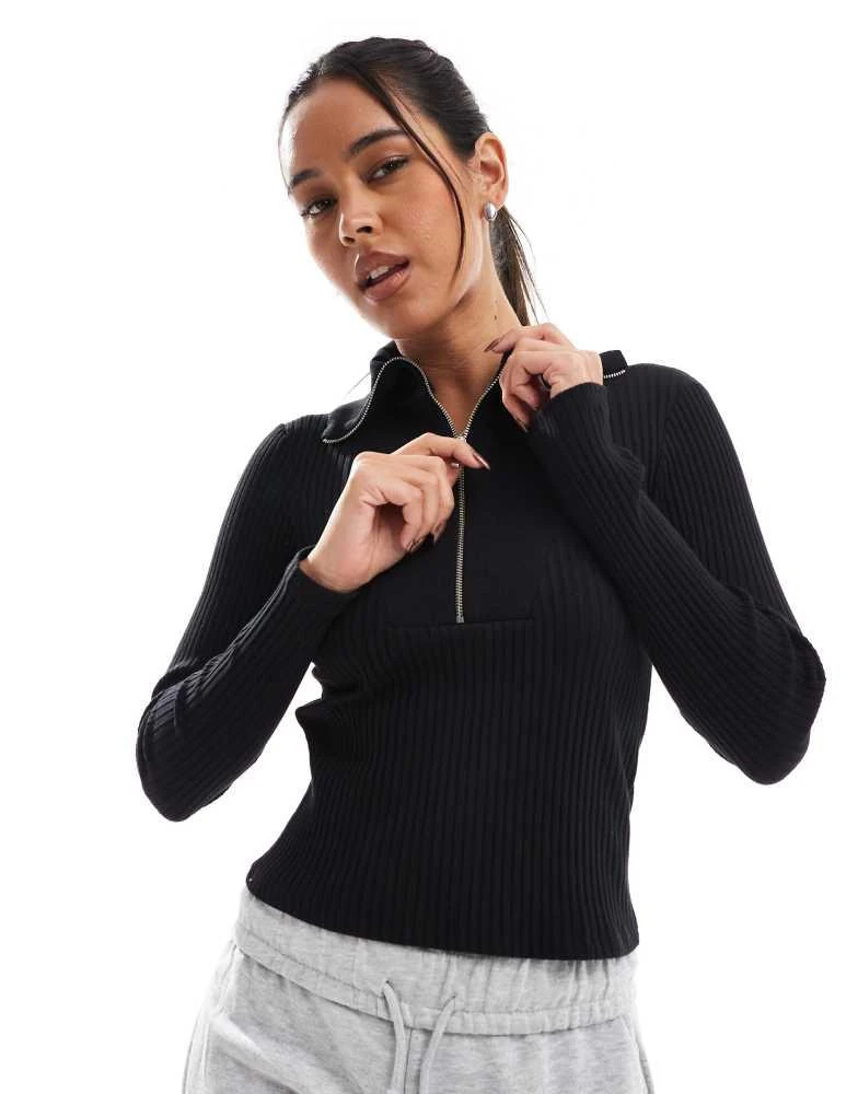 Shop Stradivarius quarter zip long sleeve knitted top in black on