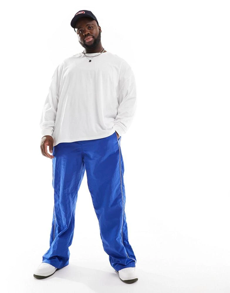 ASOS ASOS DESIGN baggy nylon track pants in blue with white piping 2
