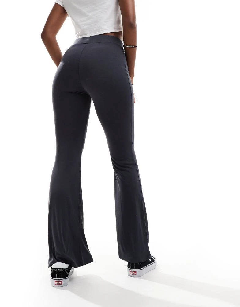 Shop Monki super soft low waist flare jersey trousers in black on