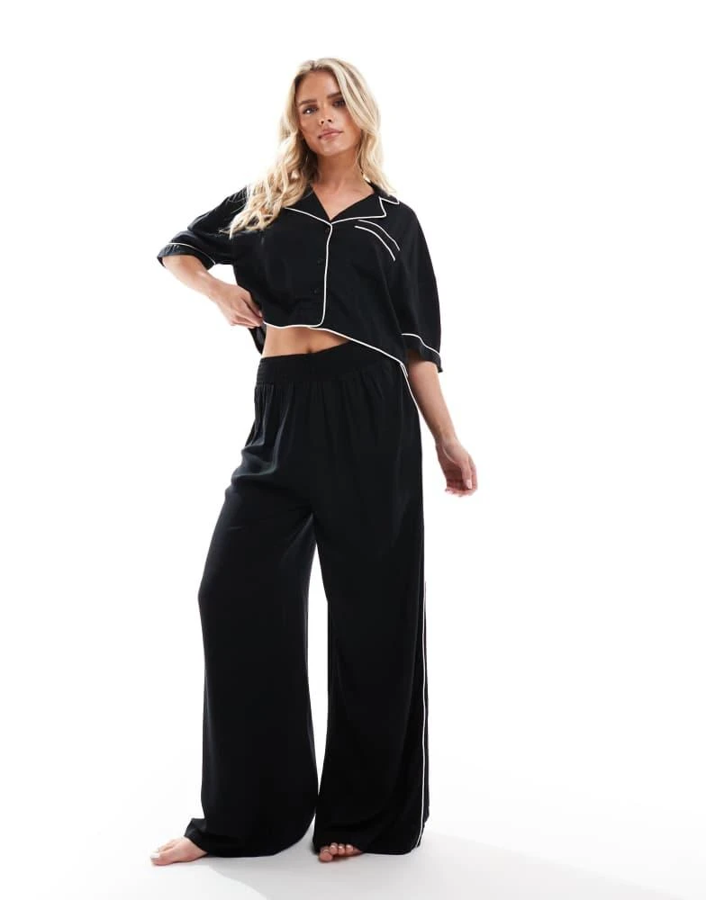 ASOS ASOS DESIGN Petite super soft slinky wide leg pyjama trouser in black with contrast binding 4