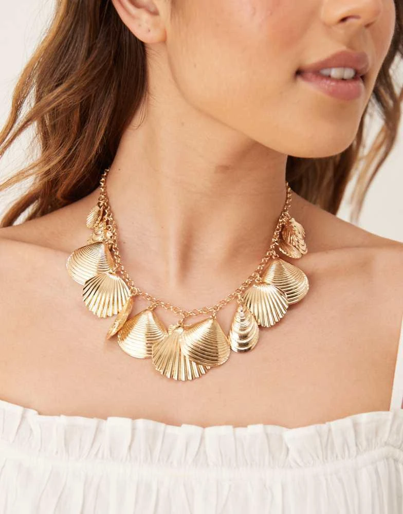 Shop Accessorize Michelle shell charm statement necklace in gold