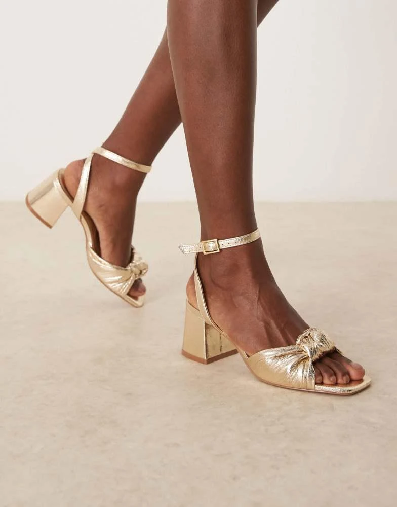 Shop ASOS DESIGN Hansel knotted mid heeled sandals in gold on Sale
