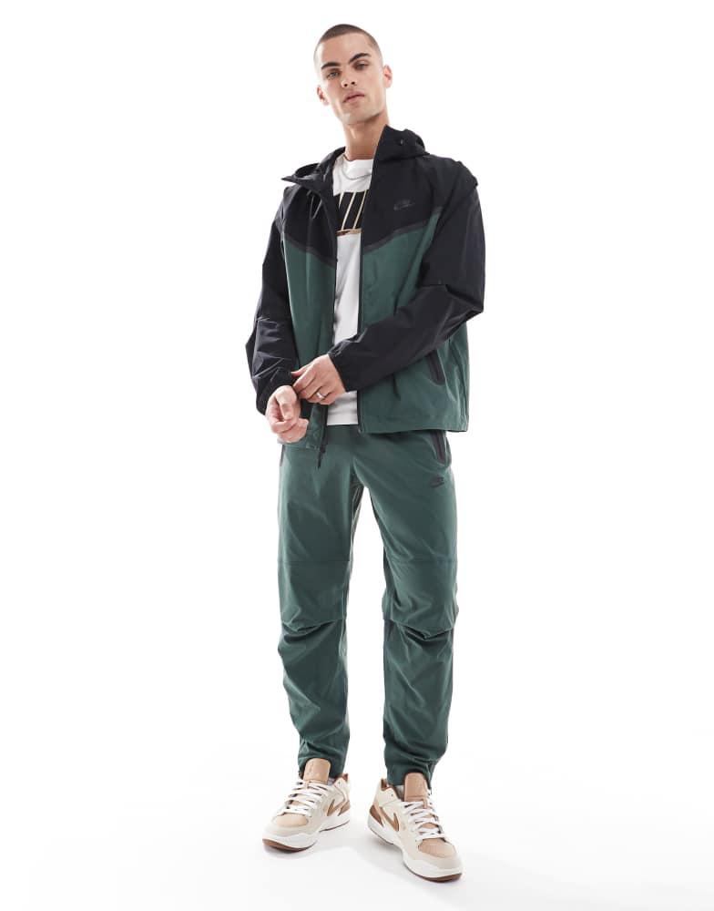Shop Nike Tech Woven full zip jacket in dark green and black on