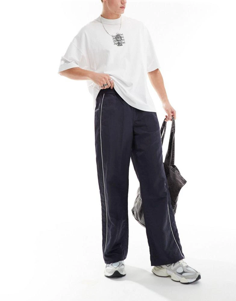 ASOS ASOS DESIGN baggy nylon track pants with white piping in navy 1