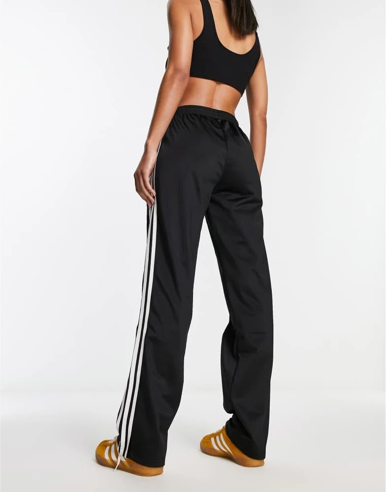 Shop adidas Originals Firebird track pants in black on Sale at