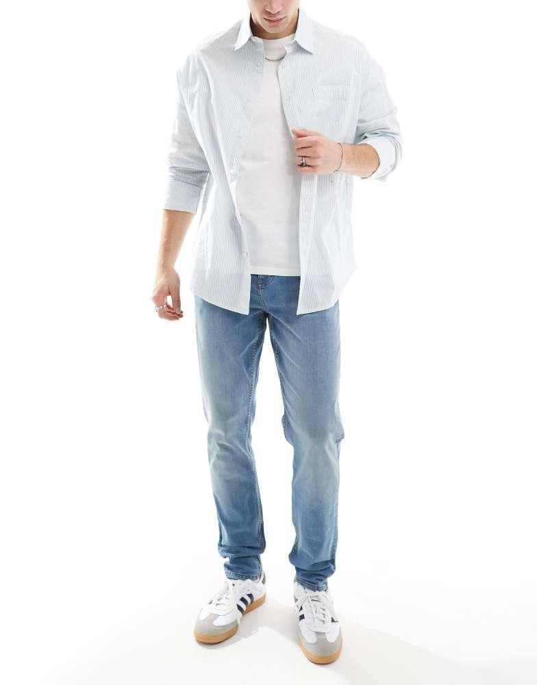 ASOS ASOS DESIGN skinny jeans with yellow tint in mid wash blue