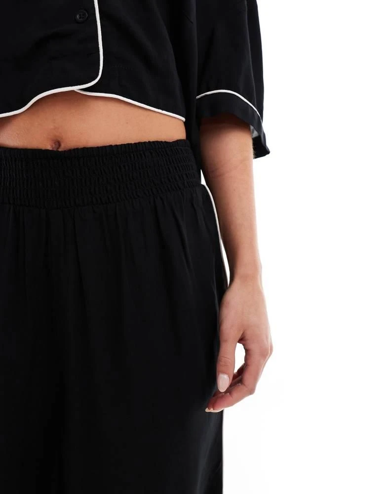 ASOS ASOS DESIGN Petite super soft slinky wide leg pyjama trouser in black with contrast binding 5