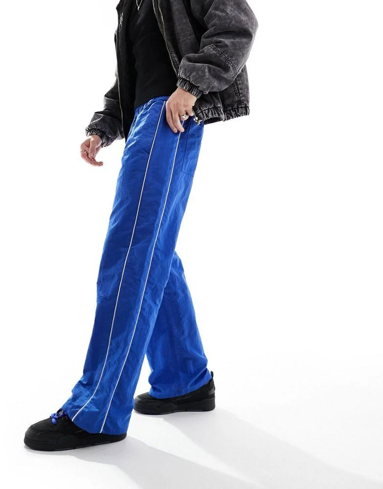 ASOS ASOS DESIGN baggy nylon track pants in blue with white piping 5